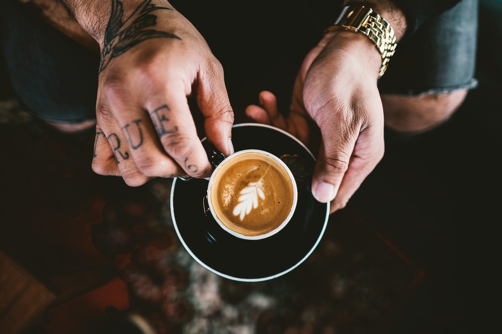 person holding double-compound leaf coffee art